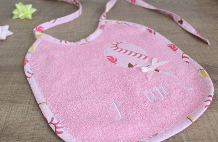 Bavoir rose avec motifs de bonbons et inscription "I love".