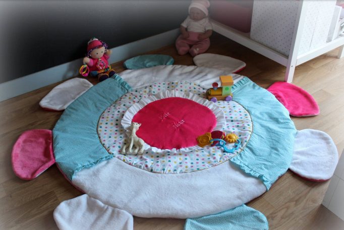 Tapis de jeu rond avec des couleurs vives et des jouets pour enfants autour.